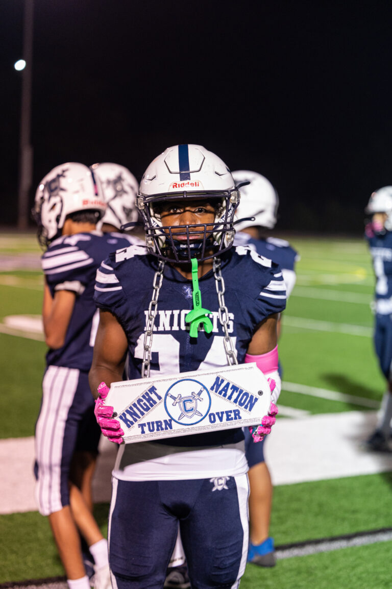 Shawn Springs II holding a turnover sign on the field.